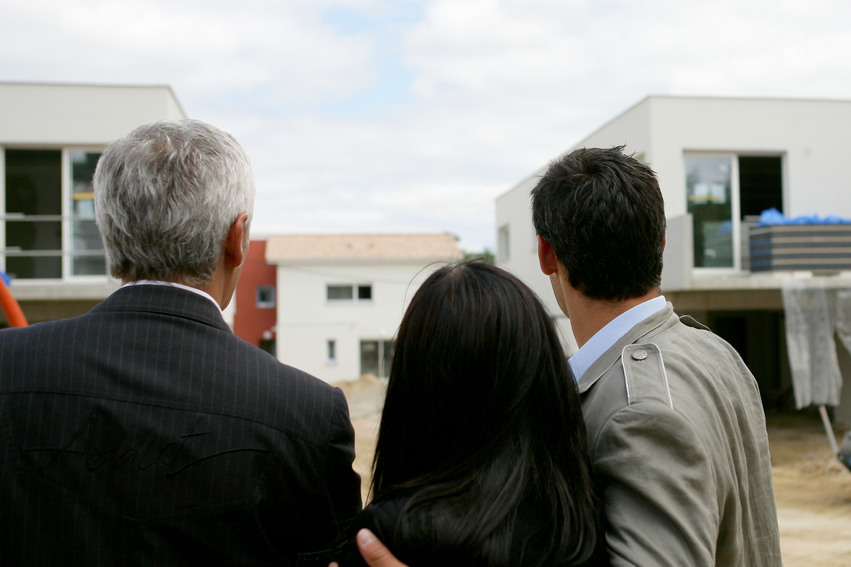 Estate agent showing a couple a housing development