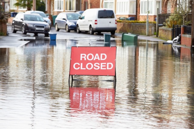 Warning Traffic Sign On Flooded Road