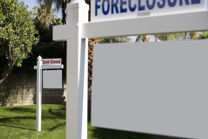 Foreclosure and Bank Owned signs in lawn