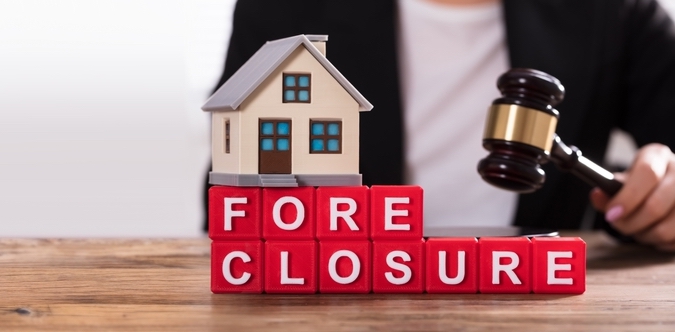 Close-up,Of,House,Model,On,Foreclosure,Cubic,Blocks,In,Front